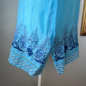 Puede incluir: Shorts de color azul claro con intrincados bordados florales en azul oscuro a lo largo del dobladillo. Los shorts est&aacute;n hechos de una tela ligera. El bordado presenta patrones detallados de flores y hojas. Corte relajado.