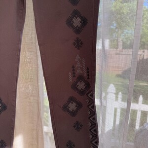 May include: A white ceramic mug with a black handle and the text "But First, Coffee" in a handwritten style. The mug is on a white surface. The mug is approximately 10 cm tall.