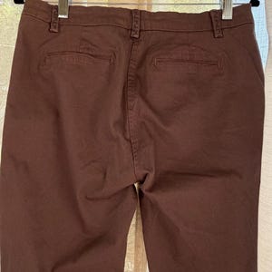 May include: A white ceramic mug with a black handle and the text "But First, Coffee" in a bold, black font. The mug is set against a neutral background, highlighting its simple design.