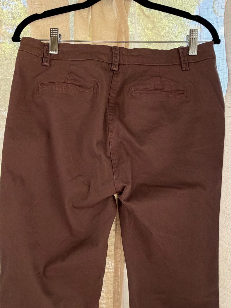 May include: A white ceramic mug with a black handle and the text "But First, Coffee" in a bold, black font. The mug is set against a neutral background, highlighting its simple design.