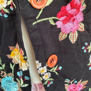 May include: A white ceramic mug with a black handle and the text "But First, Coffee" in a black, bold font. The mug is sitting on a wooden surface. The mug is approximately 4 inches tall.