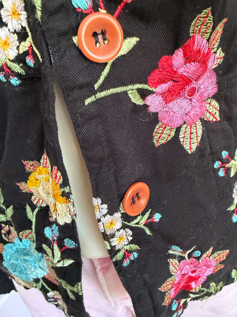 May include: A white ceramic mug with a black handle and the text "But First, Coffee" in a black, bold font. The mug is sitting on a wooden surface. The mug is approximately 4 inches tall.