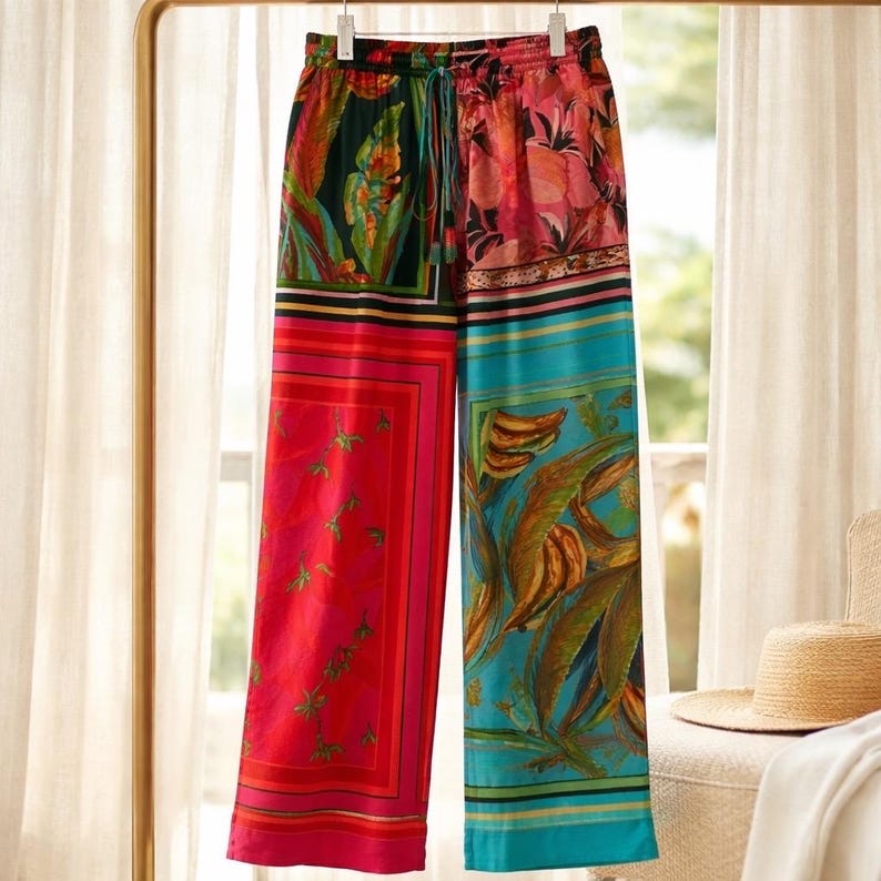 Puede incluir: Pantalones anchos y coloridos con estampado floral tropical. Los pantalones tienen cintura con cord&oacute;n y un dise&ntilde;o de patchwork con tonos vibrantes de rojo, rosa, turquesa y verde. La tela parece ligera y adecuada para el verano.