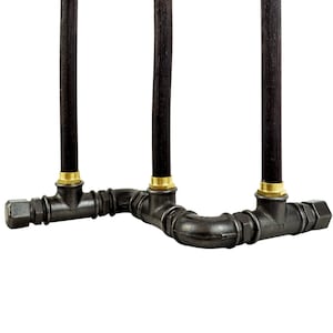 K&ouml;nnte beinhalten: Ein schwarzer Kerzenhalter aus Metall mit drei schwarzen Kerzen. Der Halter besteht aus industriellen Rohrverbindungen und hat einen rustikalen Look.