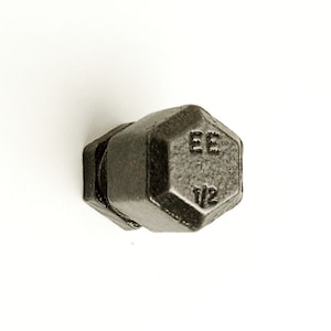 Peut inclure: Une poignée de porte en métal noir en forme d'haltère avec le texte "EE 1/2" sur le devant.