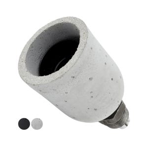 Op de afbeelding: Een cilindrische fitting met een getextureerde lichtgrijze betonnen buitenkant en een gladde zwarte binnenkant. De basis is voorzien van een metalen schroefdraadcomponent voor installatie. Twee kleine ronde kleurstalen in zwart en grijs zijn zichtbaar.