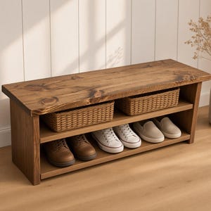 May include: A rectangular wooden shoe bench with a dark brown finish, featuring a flat top surface, one middle shelf holding two woven wicker baskets, and a bottom shelf containing two brown leather shoes, two white sneakers, and two beige slip-ons.