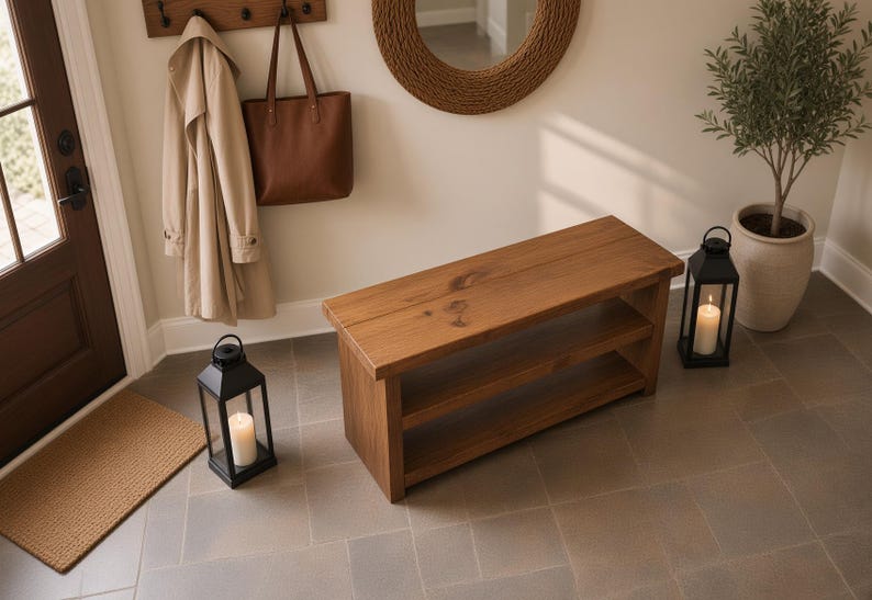 May include: A rectangular wooden bench featuring a natural brown finish with visible wood grain and a single lower shelf for storage. The bench is constructed from solid planks and has a smooth, flat top surface with a sturdy, block-style base design.