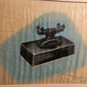 May include: A black and silver vintage-style telephone with a red button on the top. The phone is sitting on a black rectangular base.