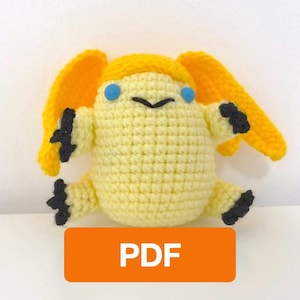 May include: A yellow crocheted plush toy featuring long ears, small blue eyes, a black stitched mouth, and black-tipped paws. The creature has a rounded body and is displayed with an orange rectangular graphic containing the white text PDF.