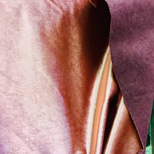 May include: Close-up of two fabric swatches. One is a soft, peach-colored velvet with a subtle sheen. The other is a deep burgundy velvet with a more textured surface.