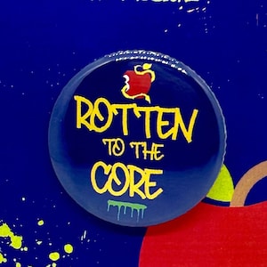 May include: A blue button with a red apple and the text "Rotten to the Core" in yellow. The button is on a card with the text "Descendants The Musical" in yellow.