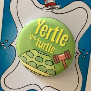 May include: A green button with the text "Yertl the turtle" in yellow letters. A cartoon turtle with a green shell and a gavel is pictured on the button.