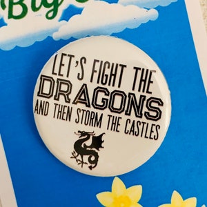 May include: White button with black text that reads "Let's Fight the Dragons and then Storm the Castles". A black silhouette of a dragon is below the text.