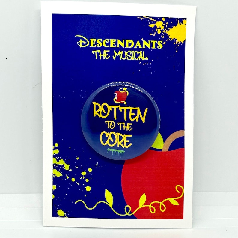 May include: A blue button with a red apple and the text "Rotten to the Core" in yellow. The button is on a card with the text "Descendants The Musical" in yellow.