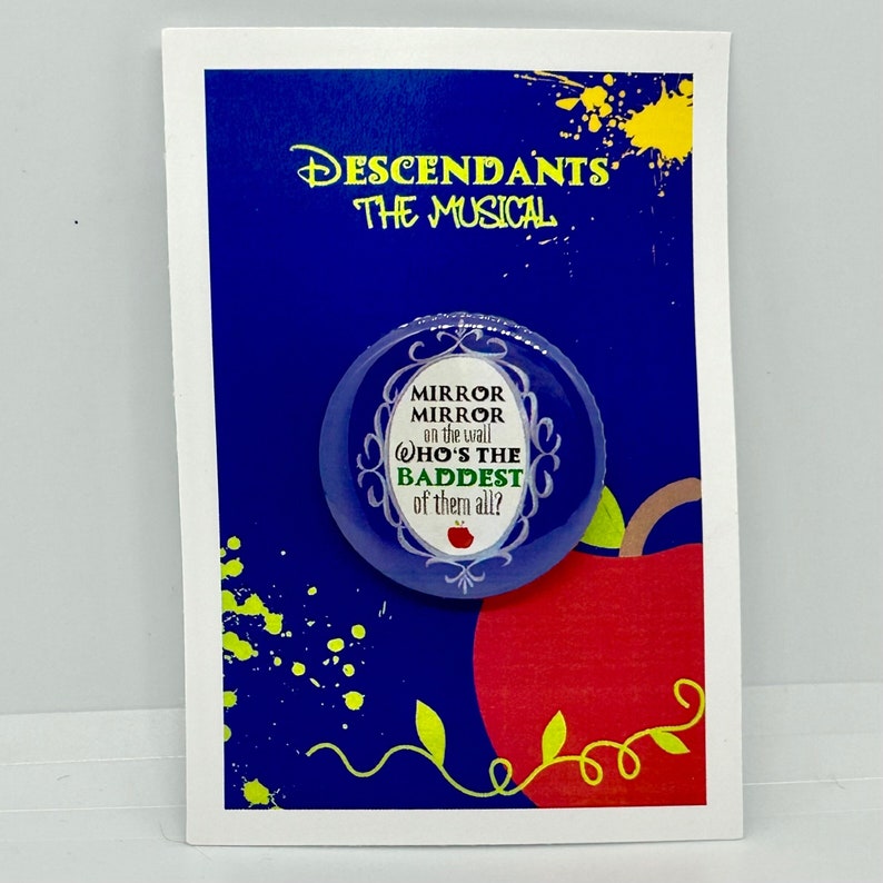 May include: A blue and white button with a quote from the Disney movie Descendants: "Mirror Mirror on the wall, who's the baddest of them all?" The button is on a white card with a red apple and green leaves.