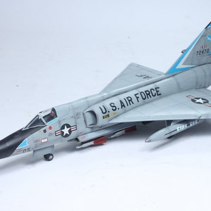 May include: A gray and white model airplane with black markings. The plane has a long, pointed nose and a swept-back wing design. The plane is labeled "U.S. AIR FORCE" and has the tail number "72470".