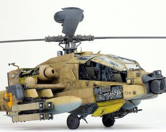 May include: A detailed model of a military helicopter with an open cockpit, featuring a tan and brown camouflage paint scheme. The helicopter has a black tail rotor and a variety of weapons and equipment attached, including missiles and a machine gun. The helicopter is labeled with the number "734".