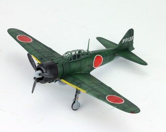 May include: A green and yellow model airplane with red circles on the wings and tail. The tail has the text "A-123" on it.