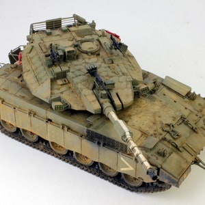 Puede incluir: Un modelo detallado de un tanque militar con un esquema de pintura de camuflaje verde. El tanque tiene una torreta grande con un cañón principal y varios cañones más pequeños. El tanque está sobre un fondo blanco.