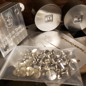 Puede incluir: Una colecci&oacute;n de herramientas y hardware para trabajar metales. La imagen presenta un bloque de metal cuadrado con el texto "Brendvik Tools 1" Square Concho", dos sellos de metal circulares con un dise&ntilde;o de sol cuadrado y una bolsa de conchos plateados.
