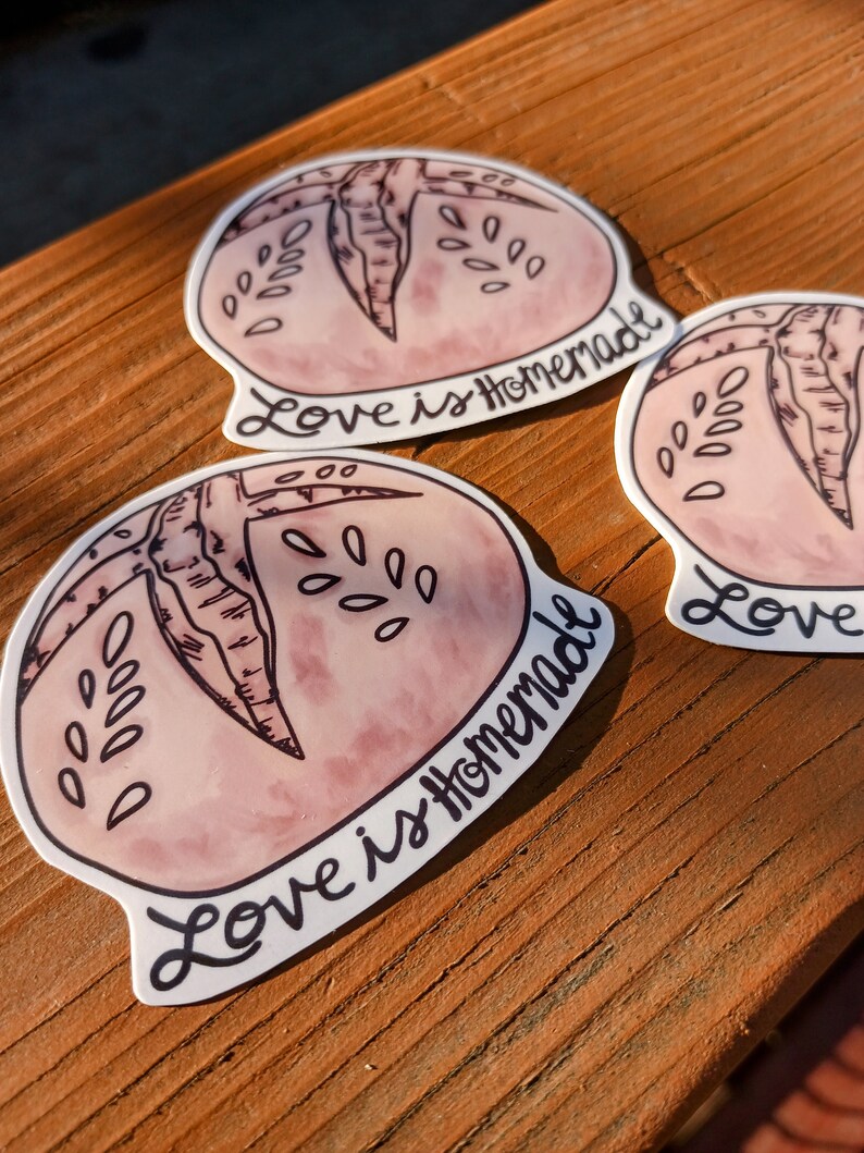 May include: Three pink and white stickers with a hand-drawn illustration of a loaf of bread. The text on the stickers reads "Love is Homemade".