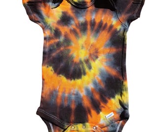 Può includere: Un body per neonato con maniche corte in tie-dye nero, arancione e giallo.