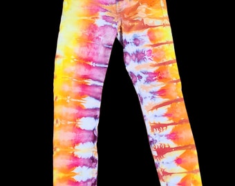 Può includere: Un paio di jeans skinny con un motivo tie-dye in tonalità di giallo, arancione, rosa e viola.