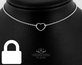 Puede incluir: Un collar de plata con un delicado colgante de corazón. El collar está en un expositor negro. El texto "CREIDHNE STUDIO Fine Jewellery" es visible debajo del expositor.