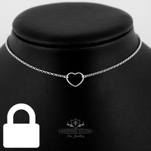 May include: A silver necklace with a delicate heart pendant. The necklace is on a black display stand. The text "CREIDHNE STUDIO Fine Jewellery" is visible below the stand.