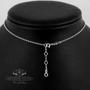 May include: A silver chain necklace with a lobster clasp and an adjustable extension chain. The necklace is displayed on a black mannequin bust.