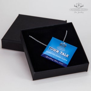 May include: A silver chain necklace in a black box with a blue and white package of Town Talk Silver Polishing Cloth. The package reads "Sparkling Since 1895".