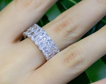 May include: A silver ring with a double row of clear pear-shaped stones.