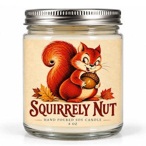 May include: A clear glass jar candle with a silver metal lid containing white wax. The label features a red squirrel holding an acorn, surrounded by autumn leaves, with the text SQUIRRELY NUT, HAND POURED SOY CANDLE, and 8 OZ printed below.