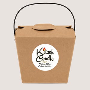 May include: A brown paper takeout-style box with a black wire handle. A circular white label on the front features the text Kitsch Candle with a small red flame icon above the letter i, and the text Modern Wax Vintage Design below.