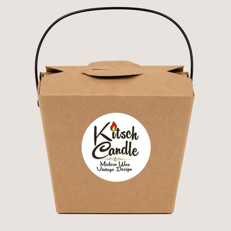 May include: A brown paper takeout-style box with a black wire handle. A circular white label on the front features the text Kitsch Candle with a small red flame icon above the letter i, and the text Modern Wax Vintage Design below.