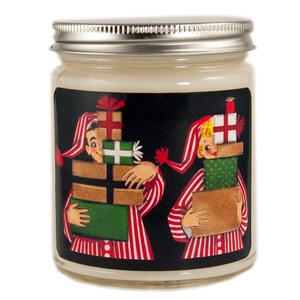 K&ouml;nnte beinhalten: Ein Kerzengef&auml;&szlig; mit einer Schwarzwei&szlig;illustration von zwei Personen im Schlafanzug, die Stapel verpackter Geschenke tragen. Der Text auf dem Etikett lautet "Frohe Weihnachten".