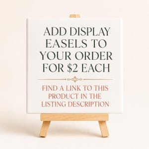 May include: A white square sign on a small wooden easel. The sign has text in dark green and red that reads "ADD DISPLAY EASELS TO YOUR ORDER" and "FIND A LINK TO THIS PRODUCT IN THE LISTING DESCRIPTION."