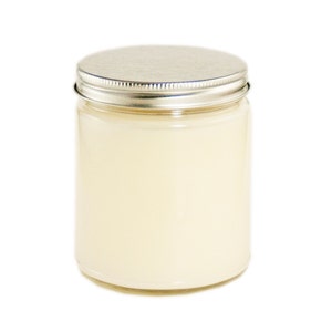 May include: A clear glass jar with a silver lid filled with a white candle.