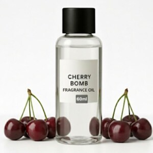May include: A clear glass bottle with a black cap labeled "CHERRY BOMB FRAGRANCE OIL 60ml" is surrounded by fresh, ripe cherries. The cherries are a deep red color with green stems, creating a vibrant and appealing display.