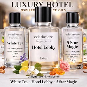 May include: Three glass fragrance oil bottles with black lids, labelled "White Tea", "Hotel Lobby", and "5 Star Magic". Each bottle contains 100 ml of oil. The image includes floral and citrus accents, with the text "3 Signature Hotel Scents".