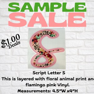 May include: A pink script letter "S" with a floral animal print design. The letter is outlined in flamingo pink vinyl. The image also includes the text "SAMPLE SALE" and "$1.00 Deals". The letter measures 4.5"W x 4"H.