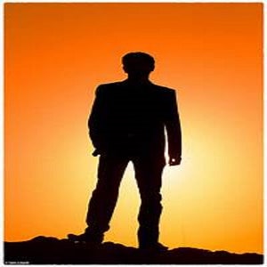 Puede incluir: Silueta de una persona de pie frente a una puesta de sol naranja brillante.