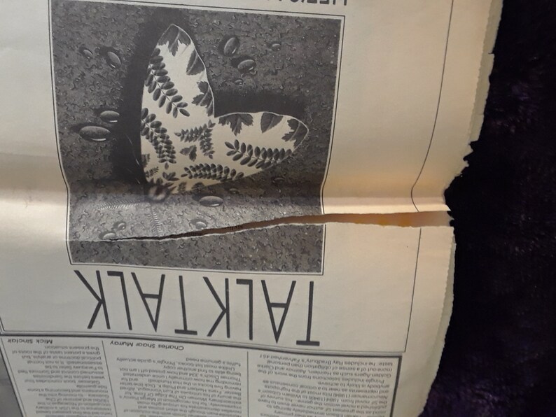 May include: Black and white newspaper page with the word "TALKTALK" in large capital letters. A detailed illustration of a butterfly with leaf-like patterns on its wings is featured. Water droplets are scattered around the butterfly.