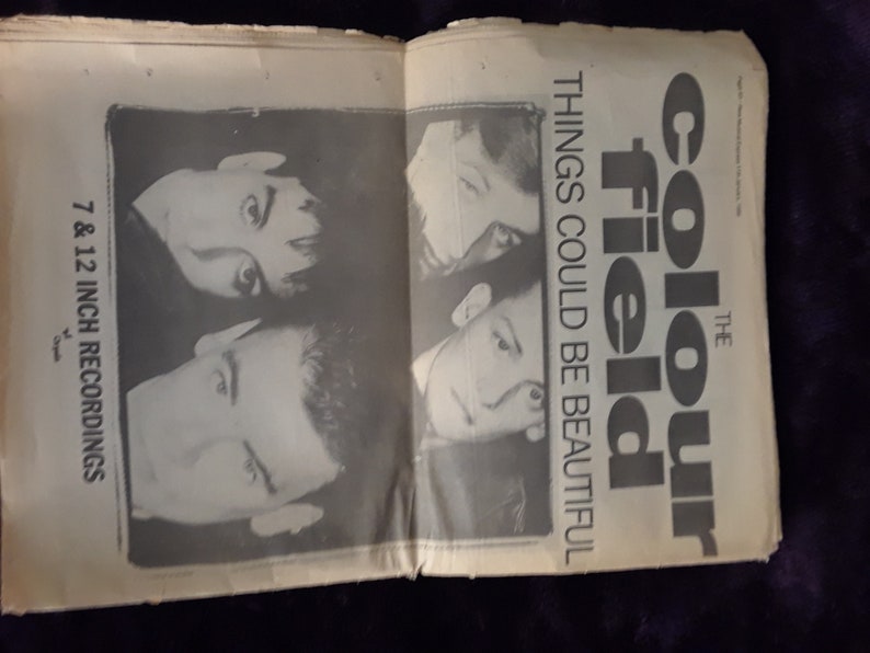 May include: An open newspaper page featuring a black and white image of a band. The text reads "The Colour Field" and "Things Could Be Beautiful". Additional text states "7 & 12 inch recordings".