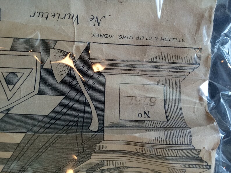 Puede incluir: Papel envejecido con una ilustraci&oacute;n detallada en blanco y negro de un hacha, formas geom&eacute;tricas y elementos arquitect&oacute;nicos. El texto "Ne Varietur" y "ST. LEIGH & CO. LTD. LITHO. SYDNEY" son visibles. Tambi&eacute;n est&aacute; presente el n&uacute;mero "8752".