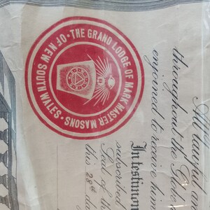Puede incluir: Documento con un sello circular rojo con la inscripci&oacute;n "THE GRAND LODGE OF MARK MASTER MASONS OF NEW SOUTH WALES". El sello rodea un emblema central con un dise&ntilde;o de tri&aacute;ngulo y ojo. El documento tiene texto manuscrito.
