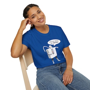 May include: Royal blue t-shirt featuring a cartoon robot with the text "ASK ME ABOUT MY WATER!!!" in a speech bubble. The robot is white with black accents and is pointing to the right. The shirt is worn by a person.