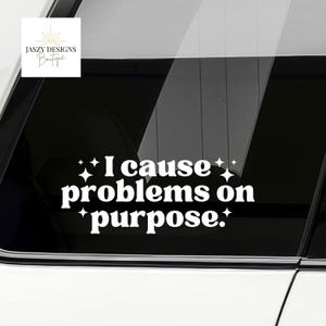 May include: White vinyl decal with the text "I cause problems on purpose" in a bold, playful font. The decal is adorned with starburst accents and the Jaszy Designs Boutique logo.