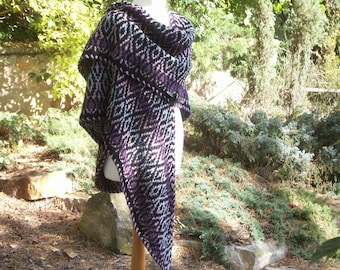 May include: A triangular shawl with a geometric pattern in shades of black, purple, and white. The shawl is draped over a mannequin.